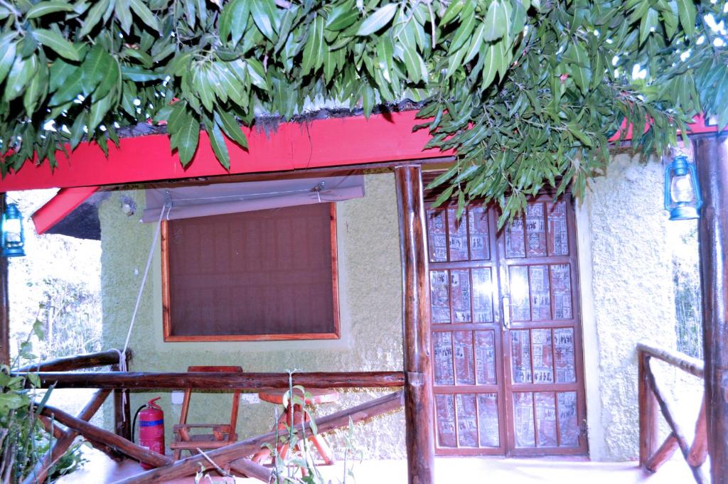 a house with a red roof and two windows at Kabalega Diner Limited in Nakitoma