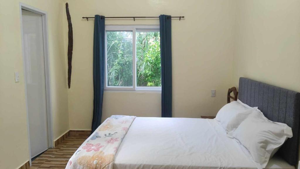 sypialnia z dużym łóżkiem i oknem w obiekcie Whitesands Beach Resort w mieście San Isidro