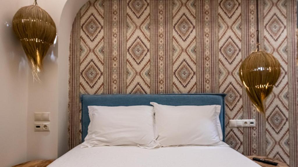 a bed with a blue headboard and two white pillows at The Cactus Project in Loutraki