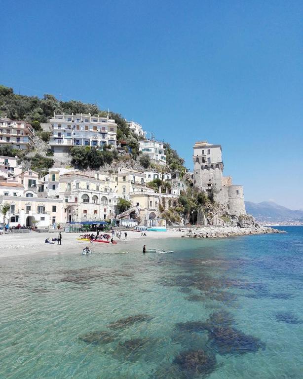a beach with people in the water and buildings at Ninni’& Nanna’ in Cetara