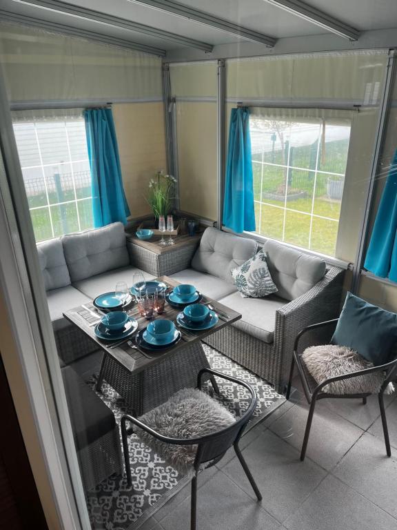 a living room with a couch and a table and chairs at Luxe Stacaravan Albatros - 51 in Bredene