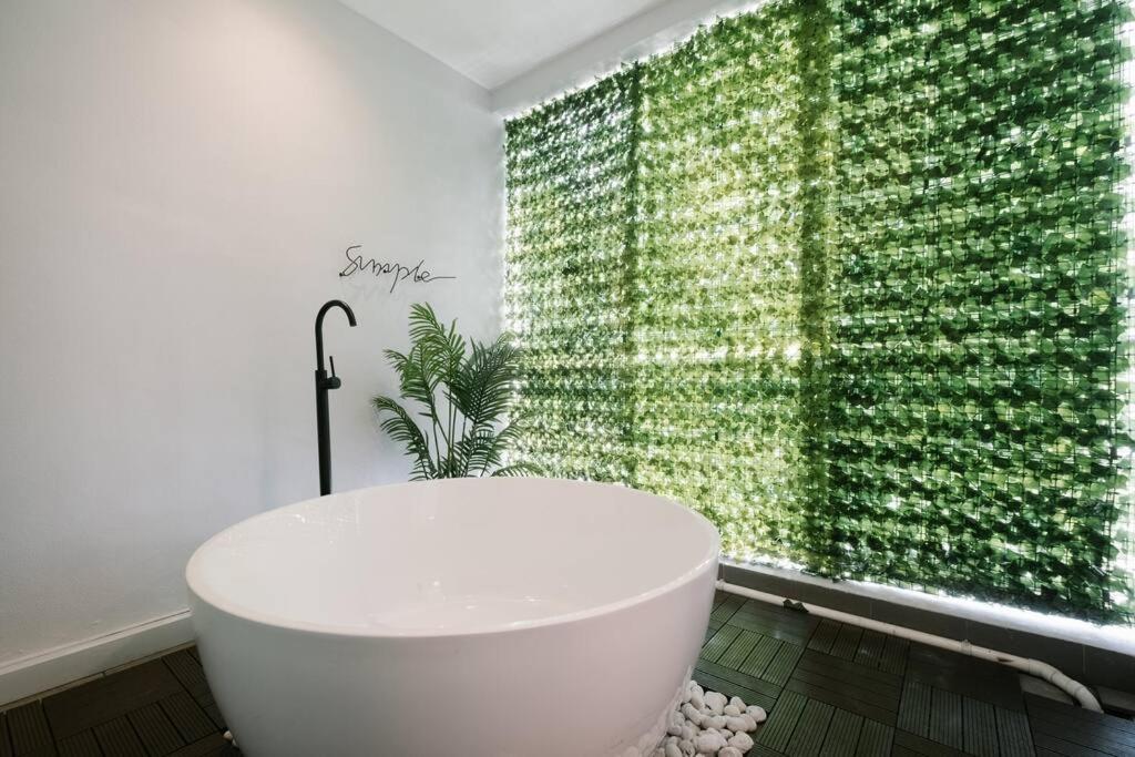 a bathroom with a white tub and a green wall at 3StoreyFamilyFriendly LakeVilla@Putrajaya@BathTub in Putrajaya