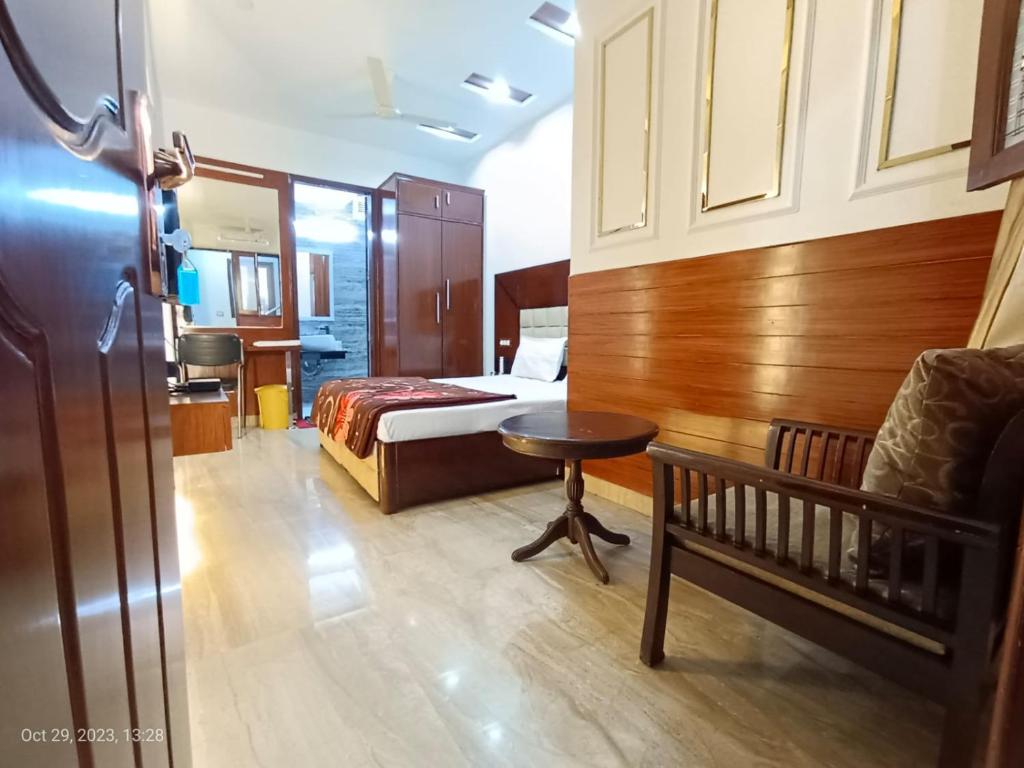 um quarto com uma cama, uma mesa e um berço em Sardar House em Nova Deli