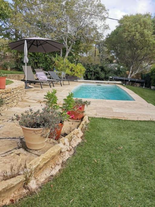 - une piscine avec un parasol et quelques plantes dans l'établissement Haut de villa VERMEER, à Six-Fours-les-Plages