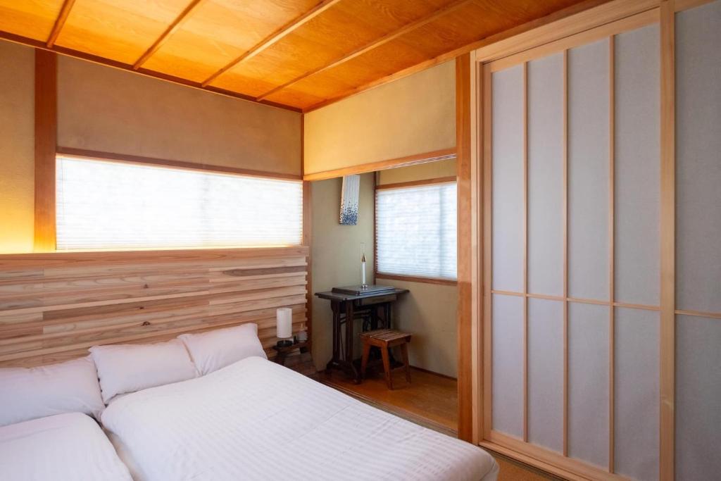 1 dormitorio con cama blanca y ventana en Tokushima - house / Vacation STAY 573 en Tokushima