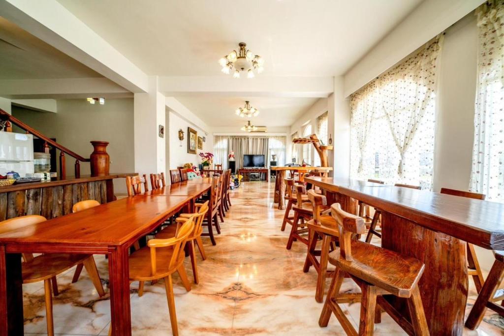 a dining room with wooden tables and chairs at Alps Garden B&amp;B in Wujie