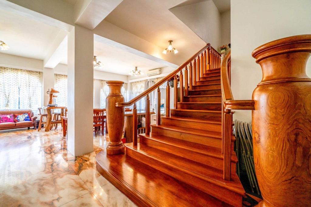 a staircase in a living room with wooden floors at Alps Garden B&amp;B in Wujie