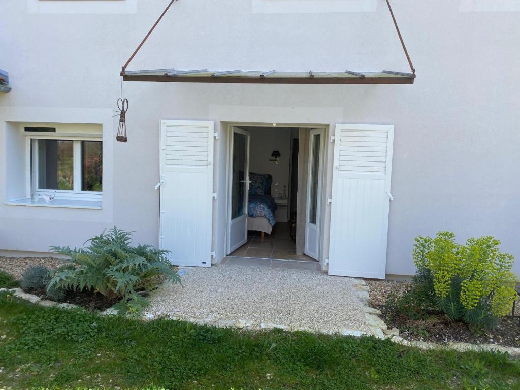 an open door of a white house with a porch at Maison d hôtes Les Chantours dans réserve naturelle 15 hectares in Saint-Antoine-Cumond
