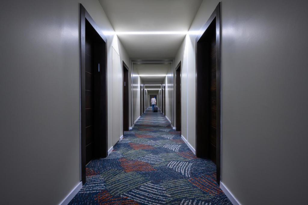 a corridor of a hallway with a long hallway at Sadot Hotel Ben Gurion Airport - an Atlas Boutique Hotel in Assaf Harofeh