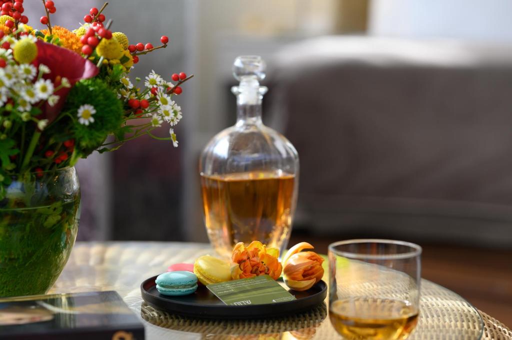 a table with a bottle of whiskey and a glass at Sadot Hotel Ben Gurion Airport - an Atlas Boutique Hotel in Assaf Harofeh