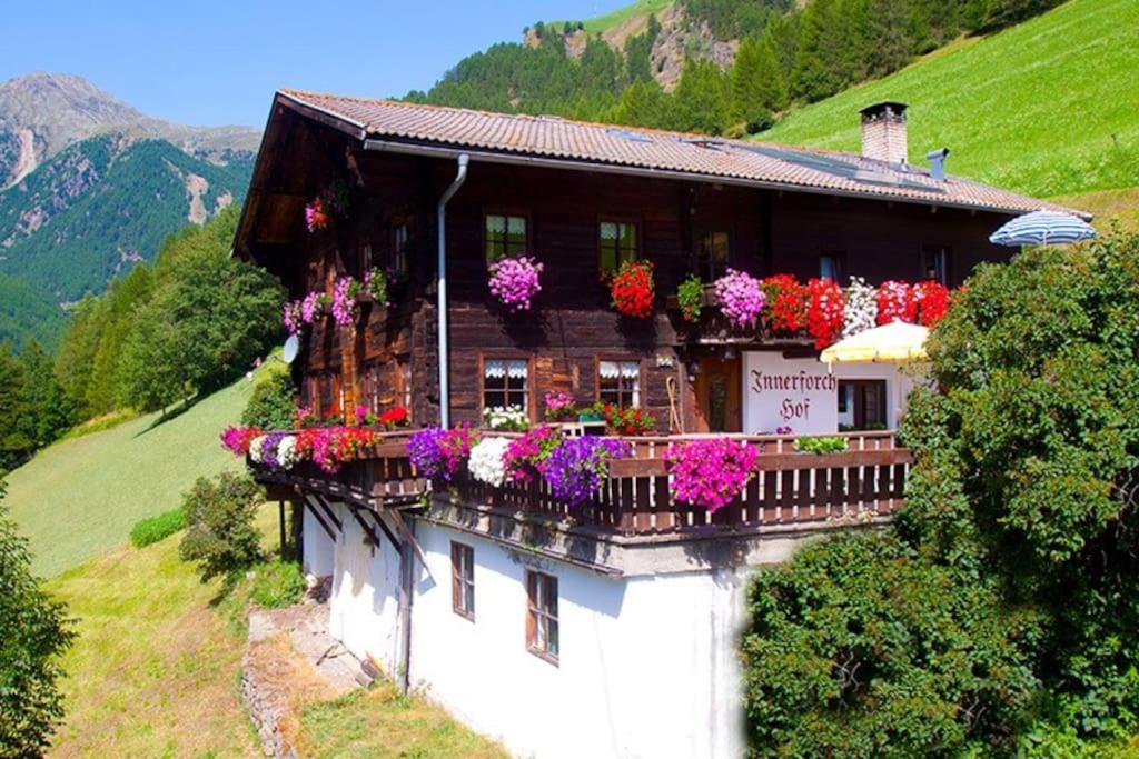 a house with lots of flowers on its balcony at Innerforchhof in Senales