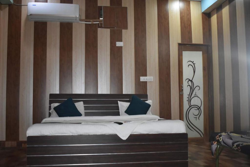 a bedroom with a large bed with blue pillows at Star inn hotel in Lucknow