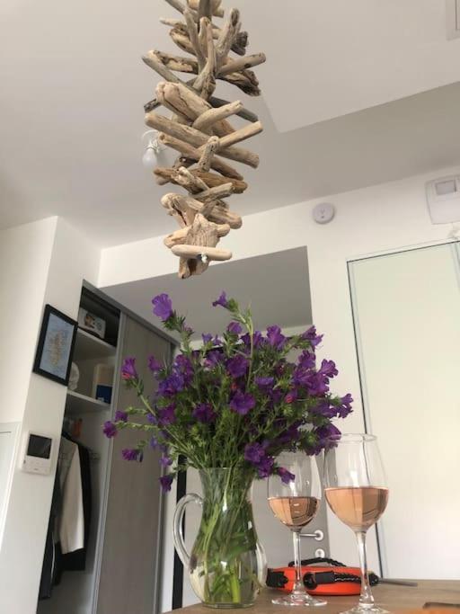 a vase with purple flowers and two glasses of wine at Piana - vue mer et village in Piana