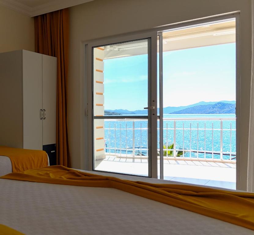 a bedroom with a window with a view of the ocean at Yazıcı Otel Bozburun in Marmaris