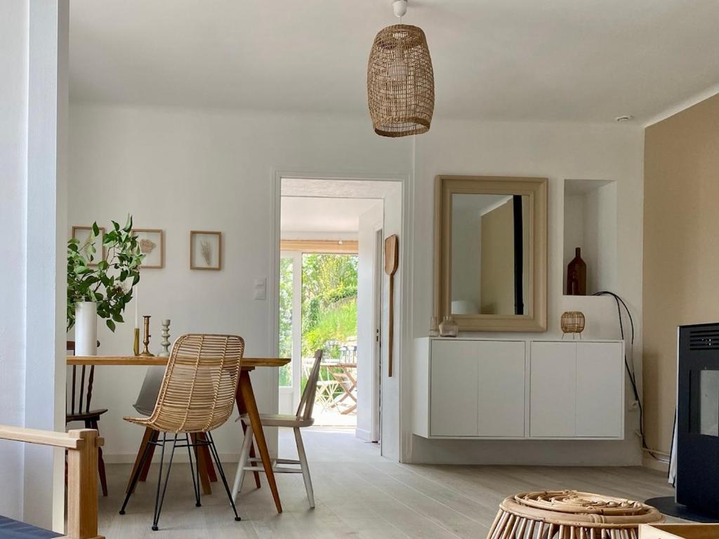 een woonkamer met een tafel en stoelen en een spiegel bij Le nid des mésanges in Buffon