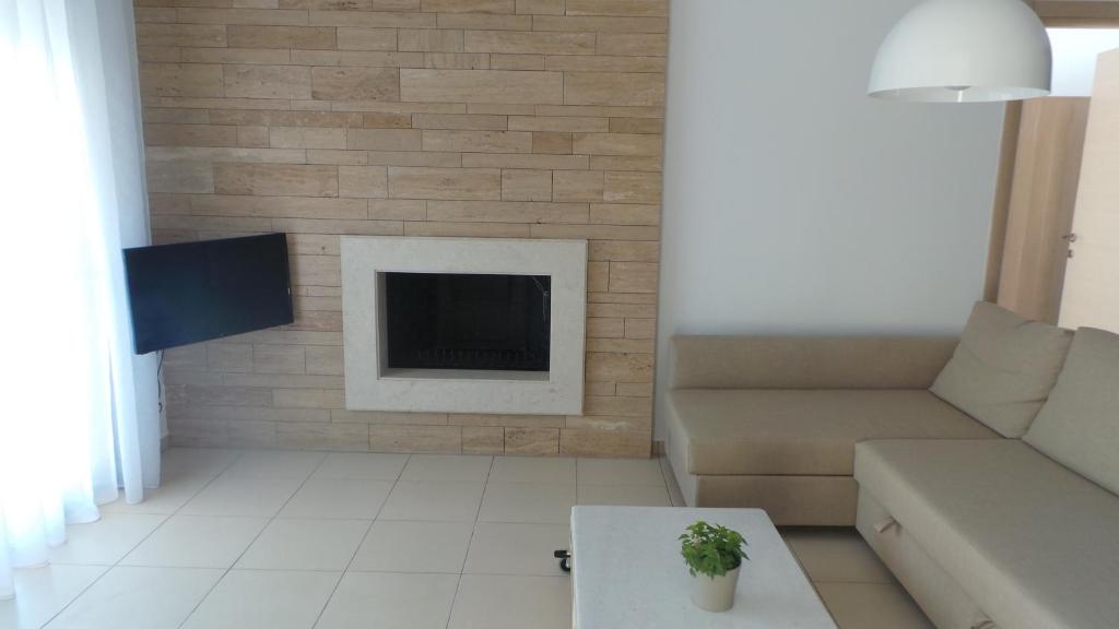 a living room with a couch and a fireplace at Niovi Boutique Apartments in Afitos