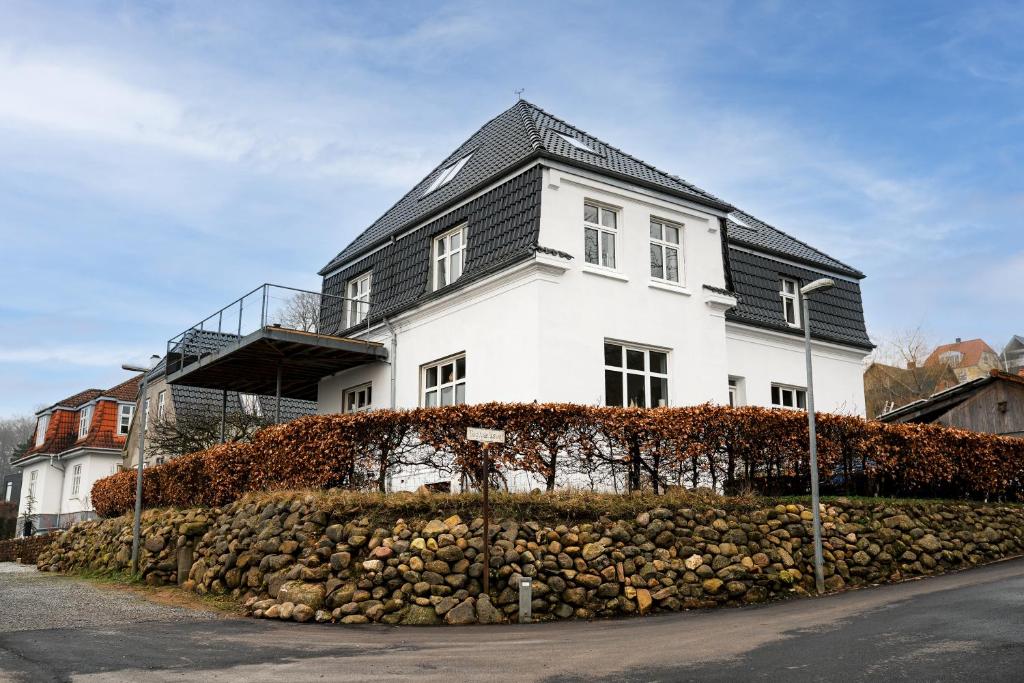 a white house with a black roof at Vila Ana - 2 room apartment in Vejle