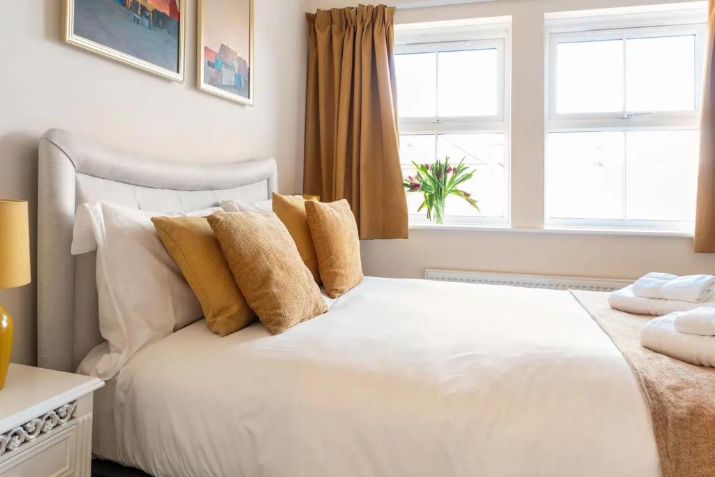 a white bed in a bedroom with two windows at Spacious 4-bedroom townhouse in the city center with free parking in Oxford