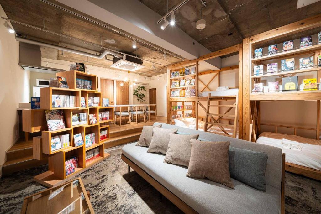 a living room with a couch and book shelves at MANGA ART HOTEL, BAKUROCHO in Tokyo
