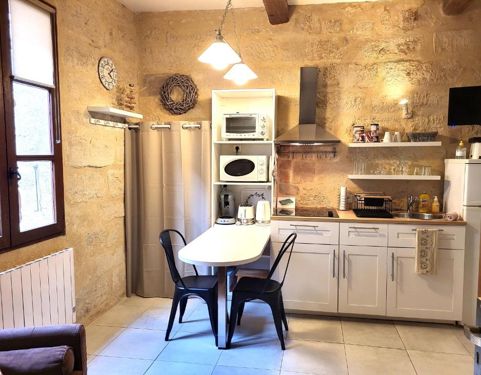 eine Küche mit einem Tisch und Stühlen im Zimmer in der Unterkunft RAVISSANT STUDIO in Uzès