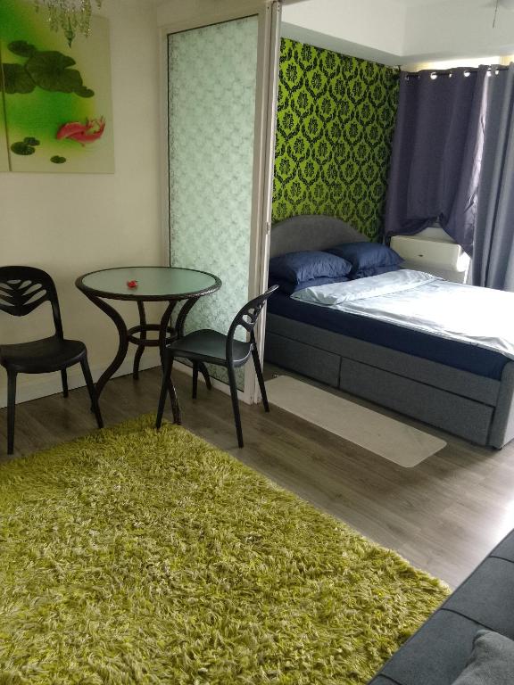 a bedroom with a bed and a table and chairs at 1bedroom with balcony in Manila