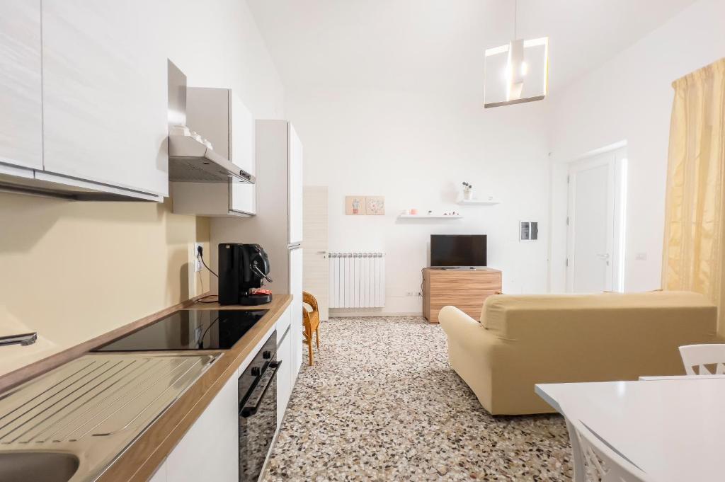 Casa vacanze Cetto e Vera في غالاتينا: مطبخ وغرفة معيشة مع أريكة