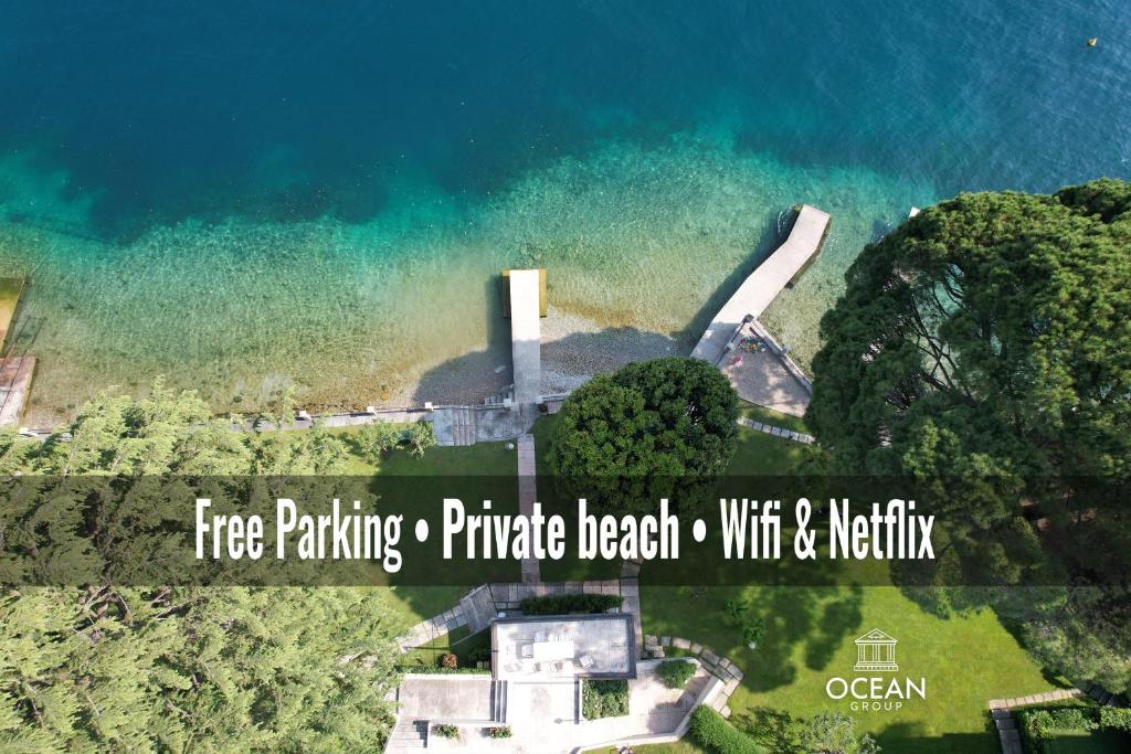 uma vista aérea de uma casa ao lado da água em OceanGroupApartments Private Beach Suite, Gardone Riviera em Gardone Riviera
