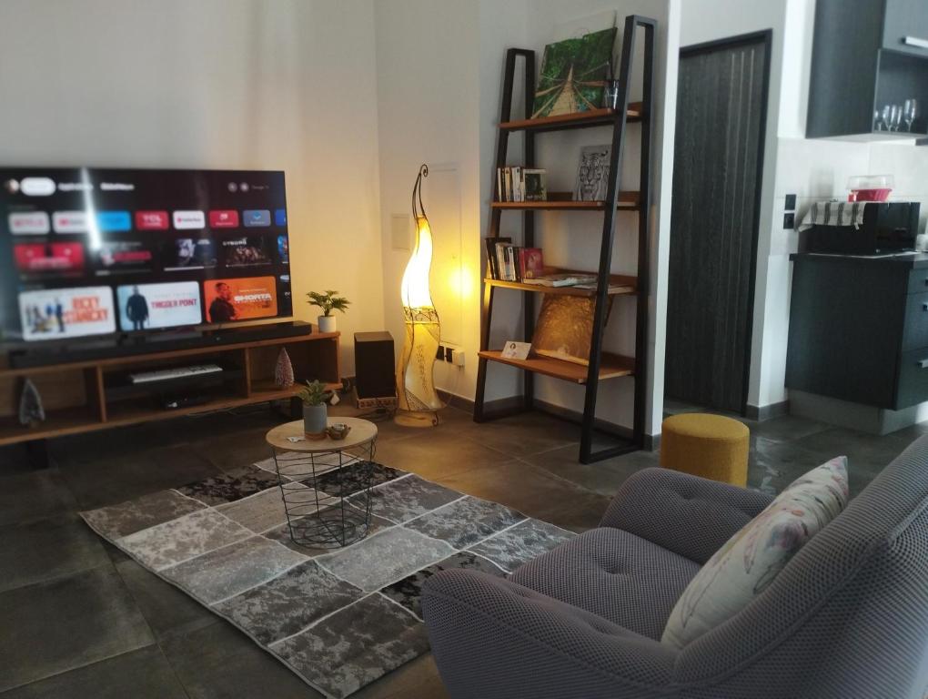 sala de estar con sofá y TV en T3 Cosy Côté Lagon, en Saint-Leu
