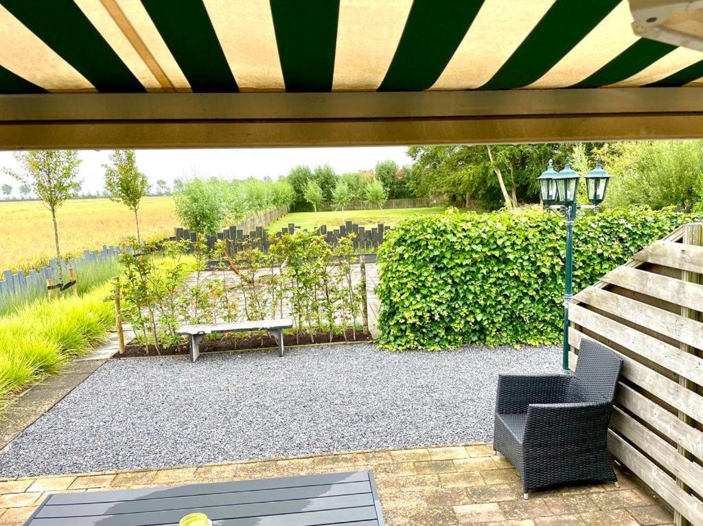 a patio with a bench and a table at Vakantiewoning de Schelp in Ellemeet