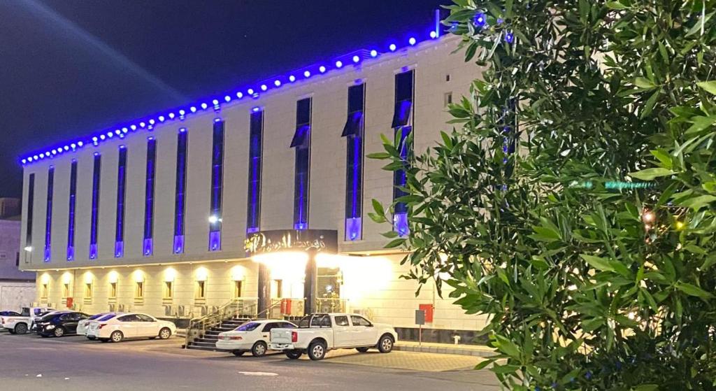 a building with cars parked in front of it at night at Zmroud Al-Morouj in Yanbu
