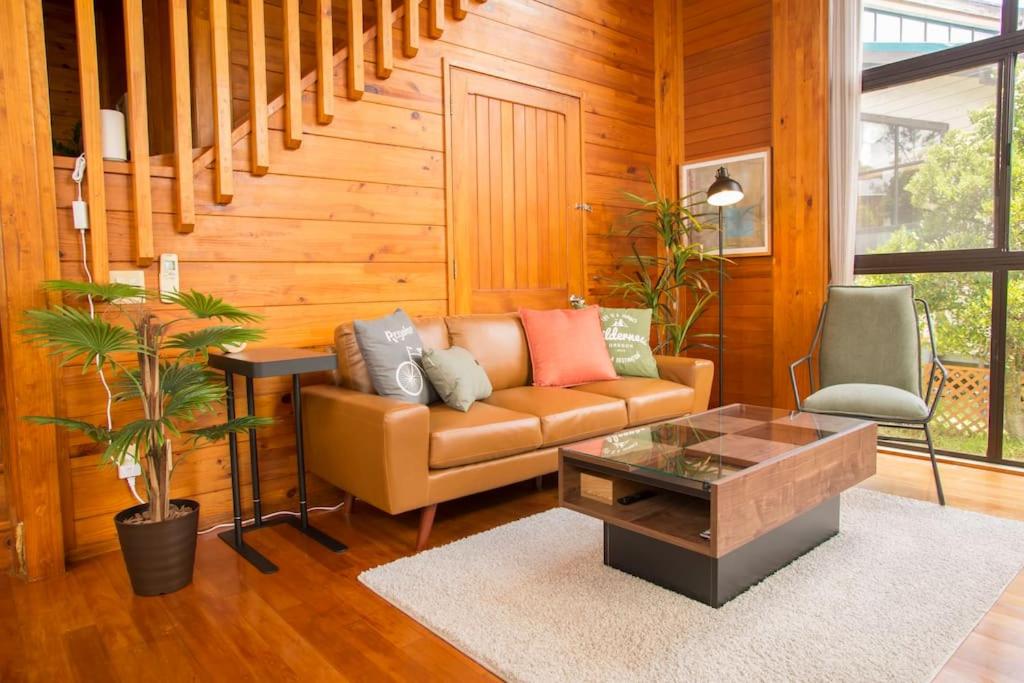 a living room with a couch and a coffee table at 木の温かみ溢れる自然の中のログハウス～Cottage HIBISCUS～ in Inbu