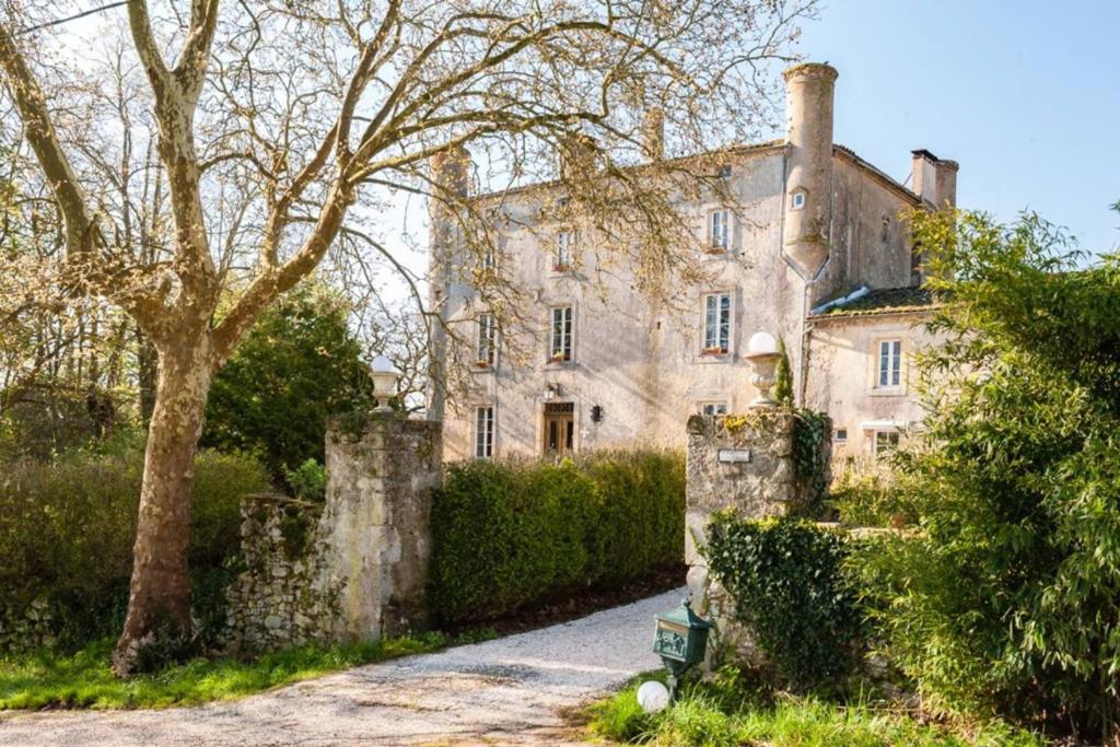 an old stone house with a tree and a driveway at Demeure de 11 chambres avec piscine partagee et wifi a Pech Luna in Pech-Luna