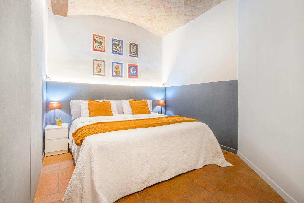 a bedroom with a large bed with orange pillows at [A 2 passi da Piazza Grande] in Modena