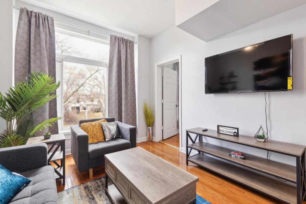 a living room with a flat screen tv on a wall at Comfortable Condo in the Heart of Bronzeville condo in Chicago