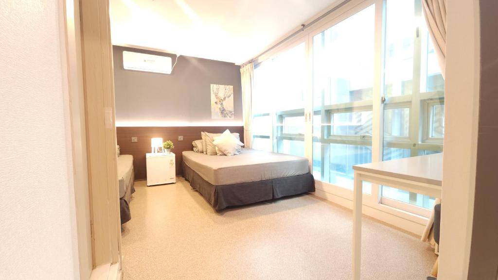 a bedroom with a bed and a large window at OYO Hostel Myeongdong 1 in Seoul