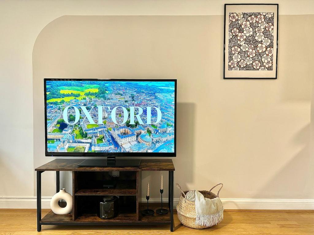 uma televisão de ecrã plano sentada numa mesa numa sala de estar em City Centre Apartment Near the University and Bodleian Library em Oxford