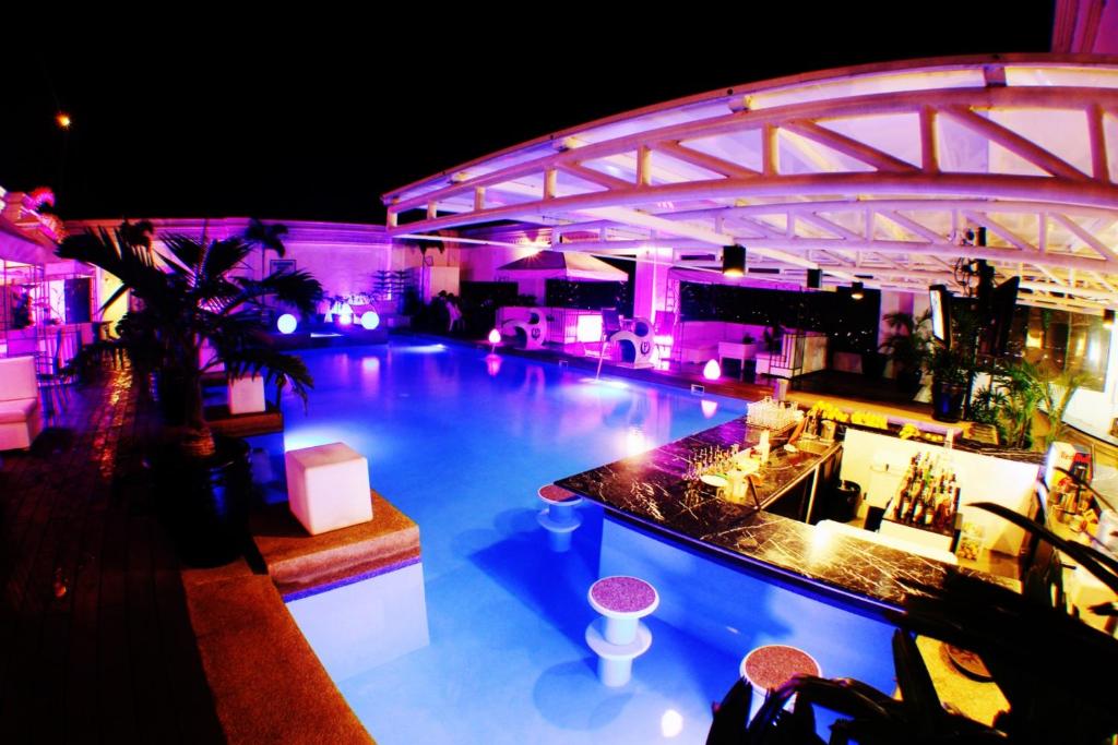 a large swimming pool with a bar in a building at The Penthouse Hotel and Residences in Angeles