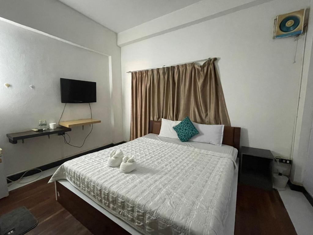 a bedroom with a white bed with two towels on it at Vientiane Star Hotel B in Vientiane