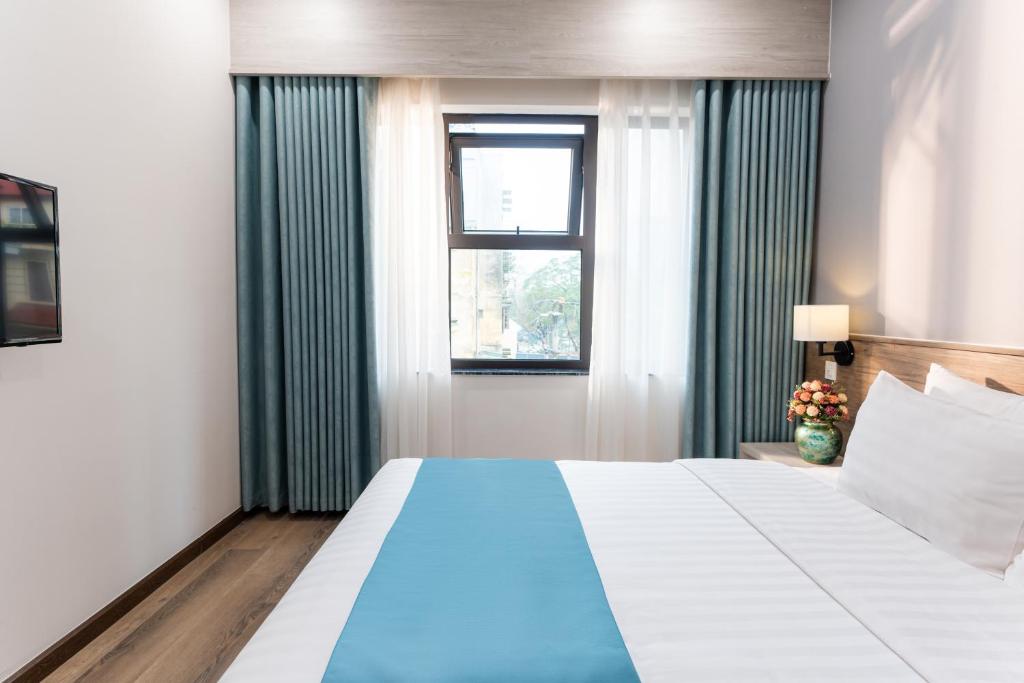 Postel nebo postele na pokoji v ubytování Capital Garden Hotel