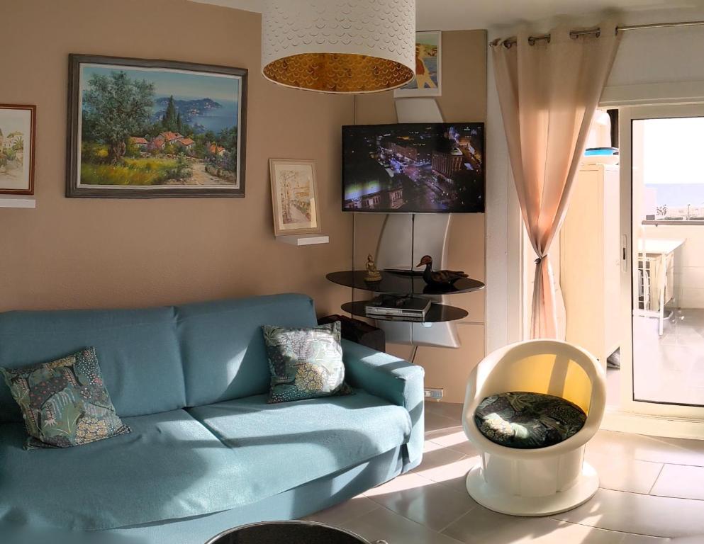 un salon avec un canapé bleu et une télévision dans l'établissement Elégant Appartement, au Barcarès