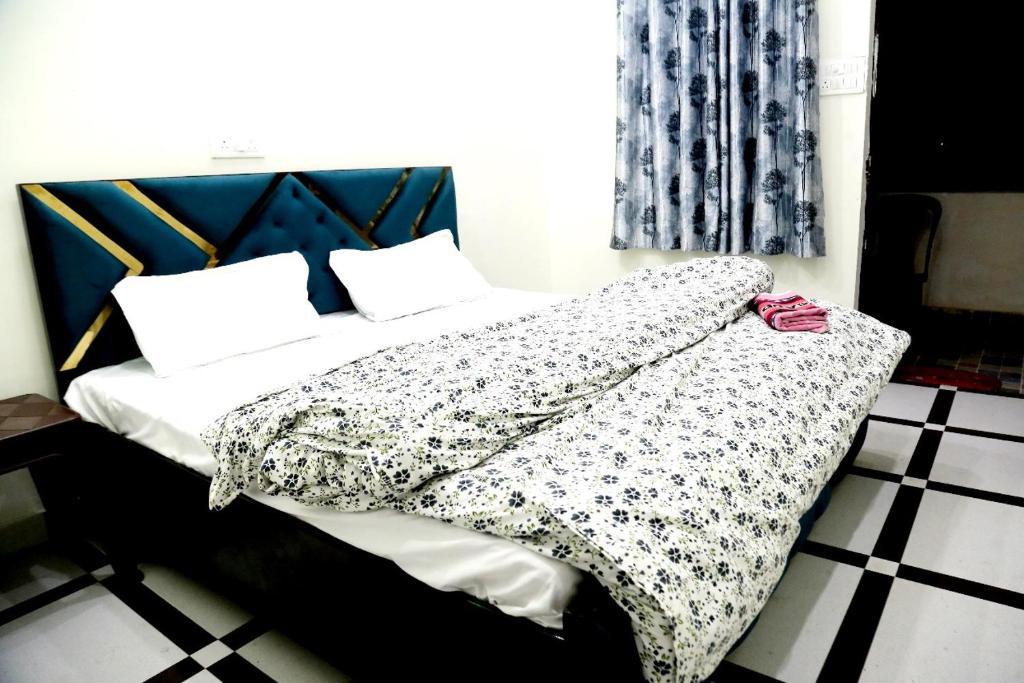 a bed with a black and white blanket on it at Jolly Hill Stay in Rāni Pokhri