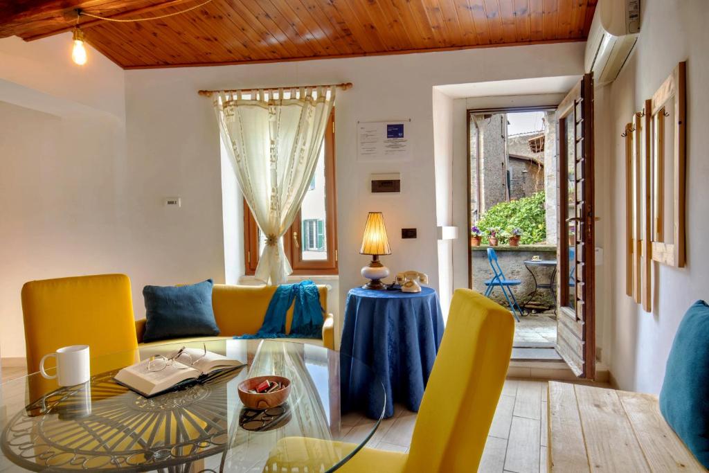 a living room with a glass table and yellow chairs at Centro e Spiaggia ambra in Anguillara Sabazia