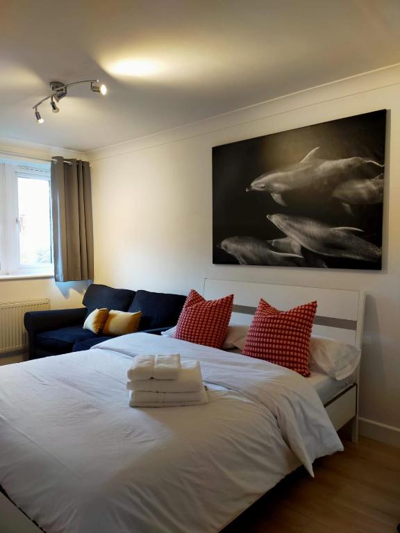 1 dormitorio con 1 cama blanca grande con almohadas rojas en COBBOLD COURT share flat en Londres