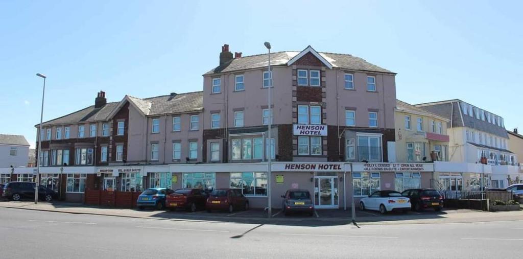 a large building with cars parked in front of it at Henson Hotel Pleasure Beach in Blackpool