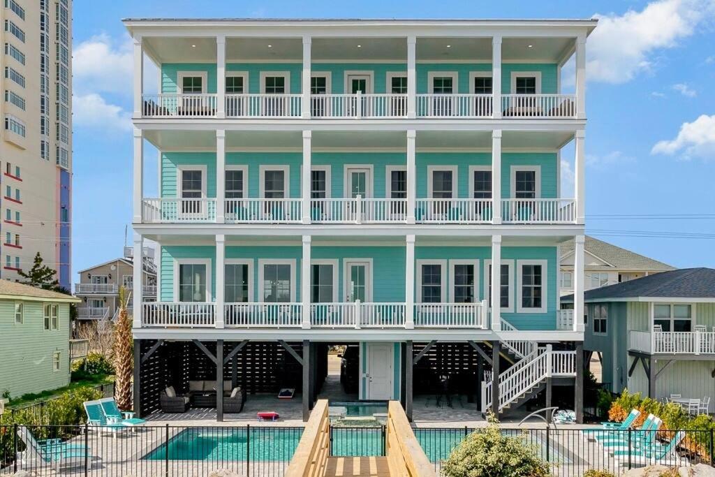 uma grande casa azul com uma piscina em frente em Carolina Escape Luxury Oceanfront Home em Myrtle Beach