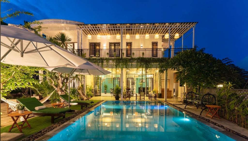 een villa met een zwembad in de nacht bij Luna Verde Hotel Hoi An in Hội An