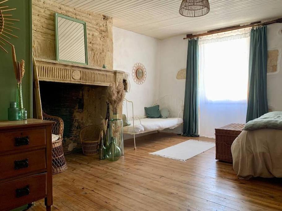 a living room with a fireplace and a bed at Maison médiévale climatisée avec jardin in Monpazier