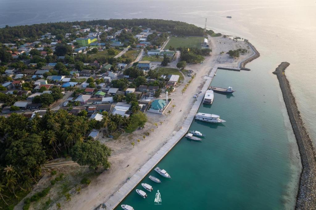 Luftaufnahme eines Strandes mit Booten im Wasser in der Unterkunft Dhonveli Hotel in Shaviyani Atoll