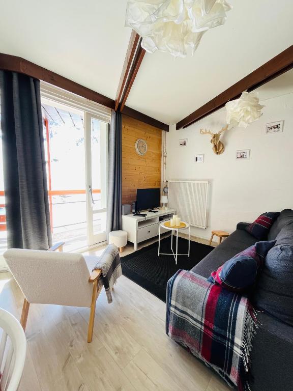 un salon avec un canapé et une télévision dans l'établissement Résidence Bero Bisto, à La Mongie