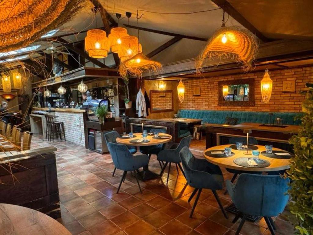 un restaurante con mesas y sillas y un bar en Bali Butique Rooms, en Nyergesújfalu